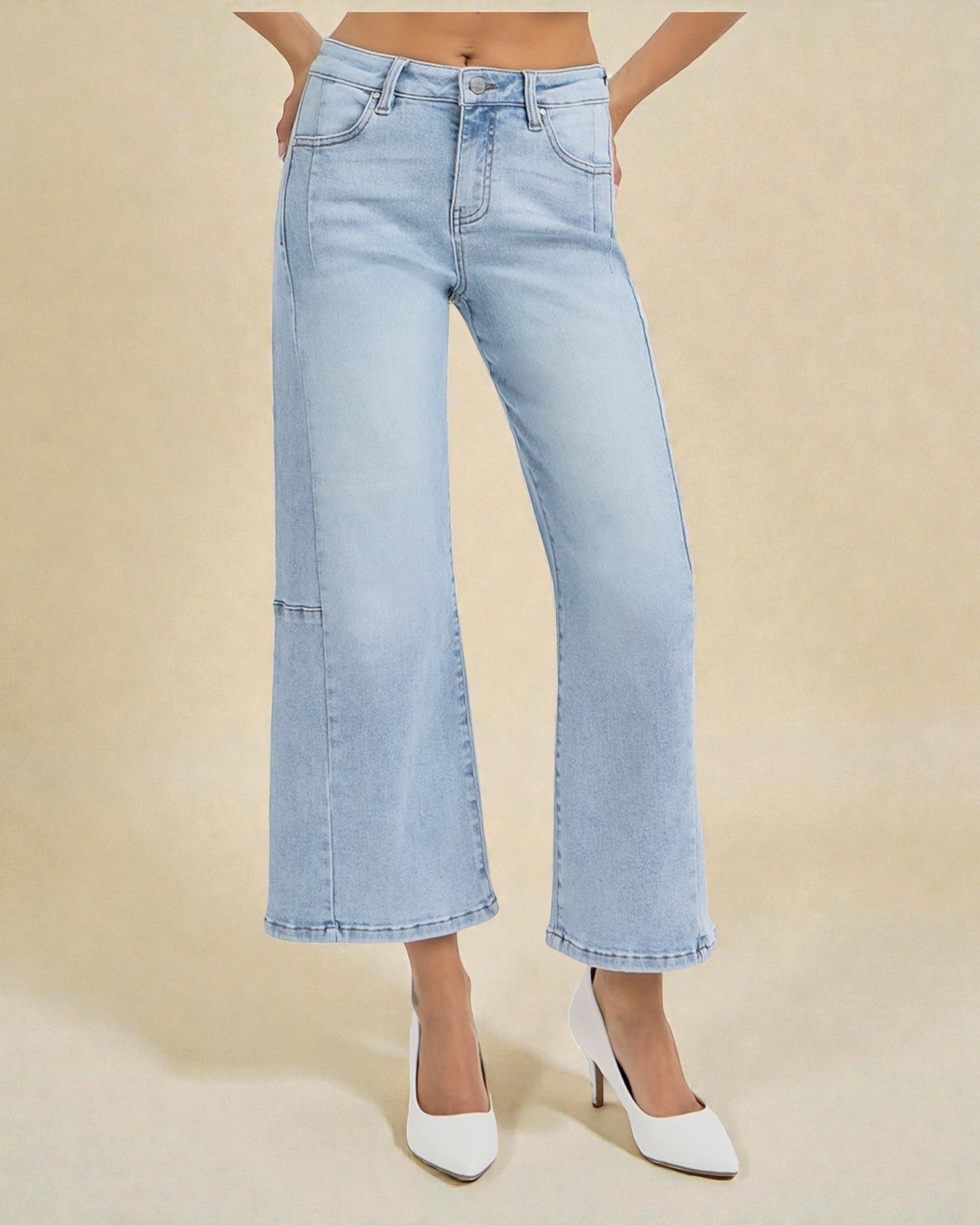 Light blue jeans worn by a person on a beige background