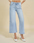 Light blue jeans worn by a person on a beige background