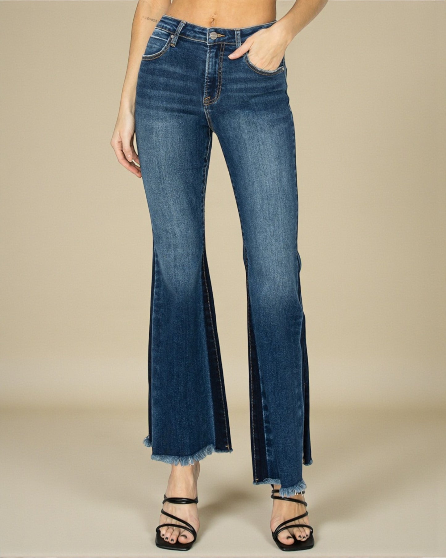 Blue flared jeans worn by a person on a beige background