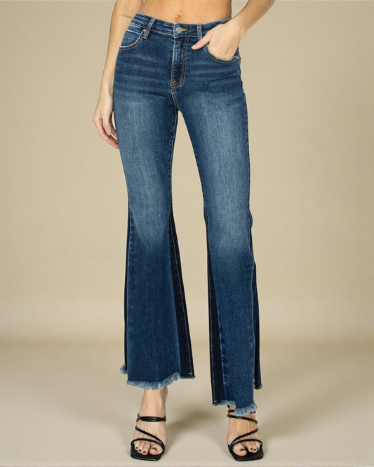 Blue flared jeans worn by a person on a beige background