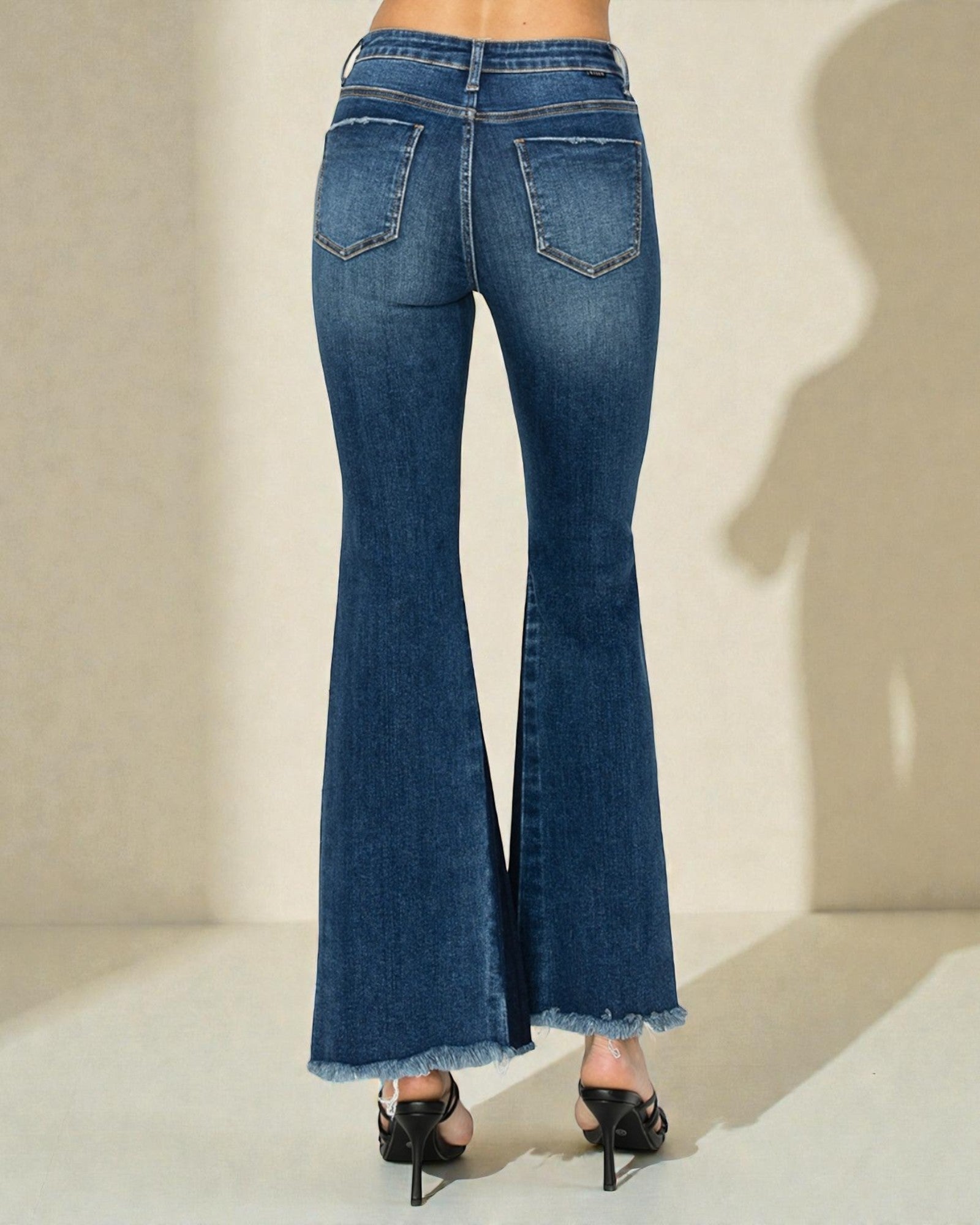 Blue flared jeans worn by a person on a neutral background