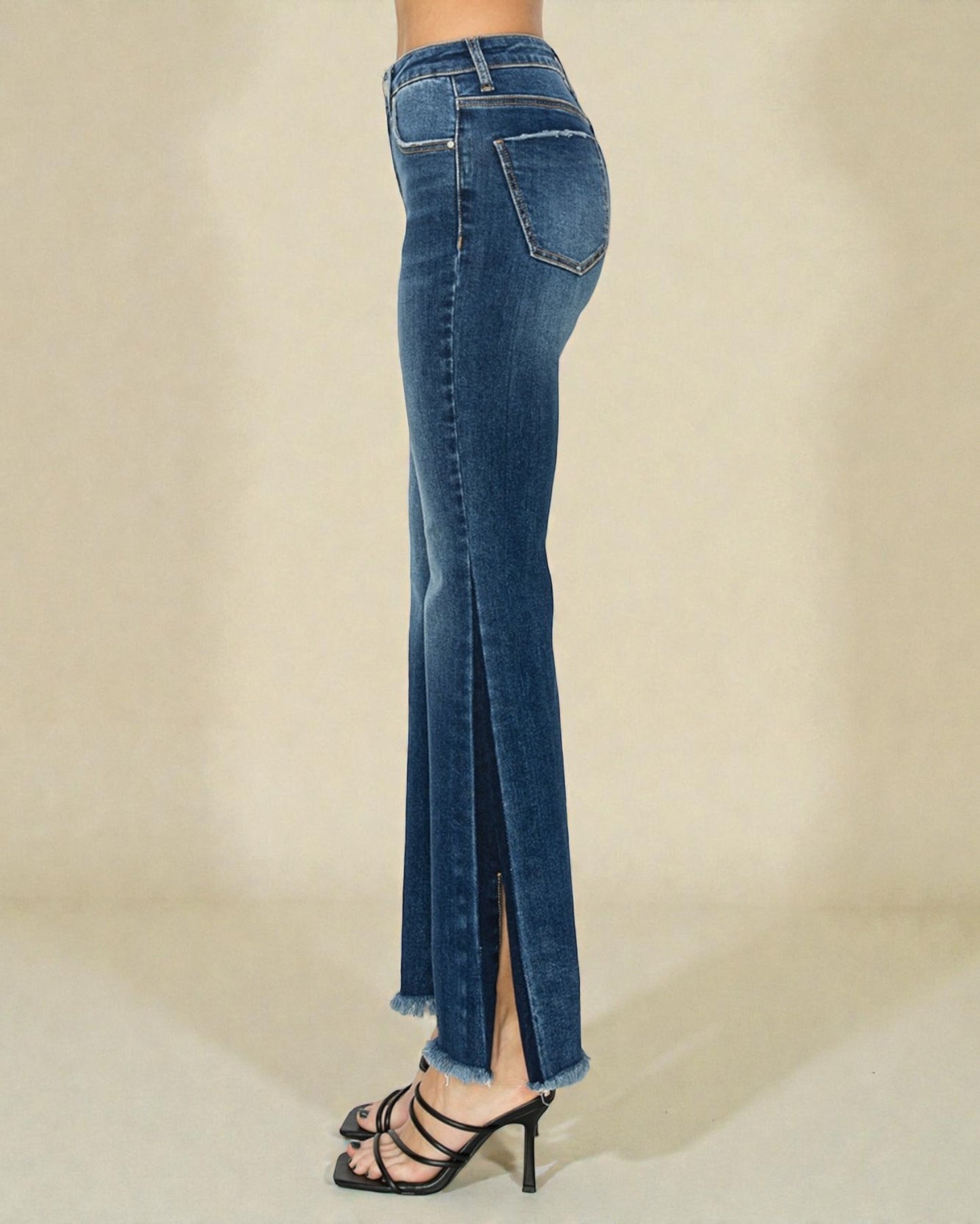Blue jeans with a slit on a beige background