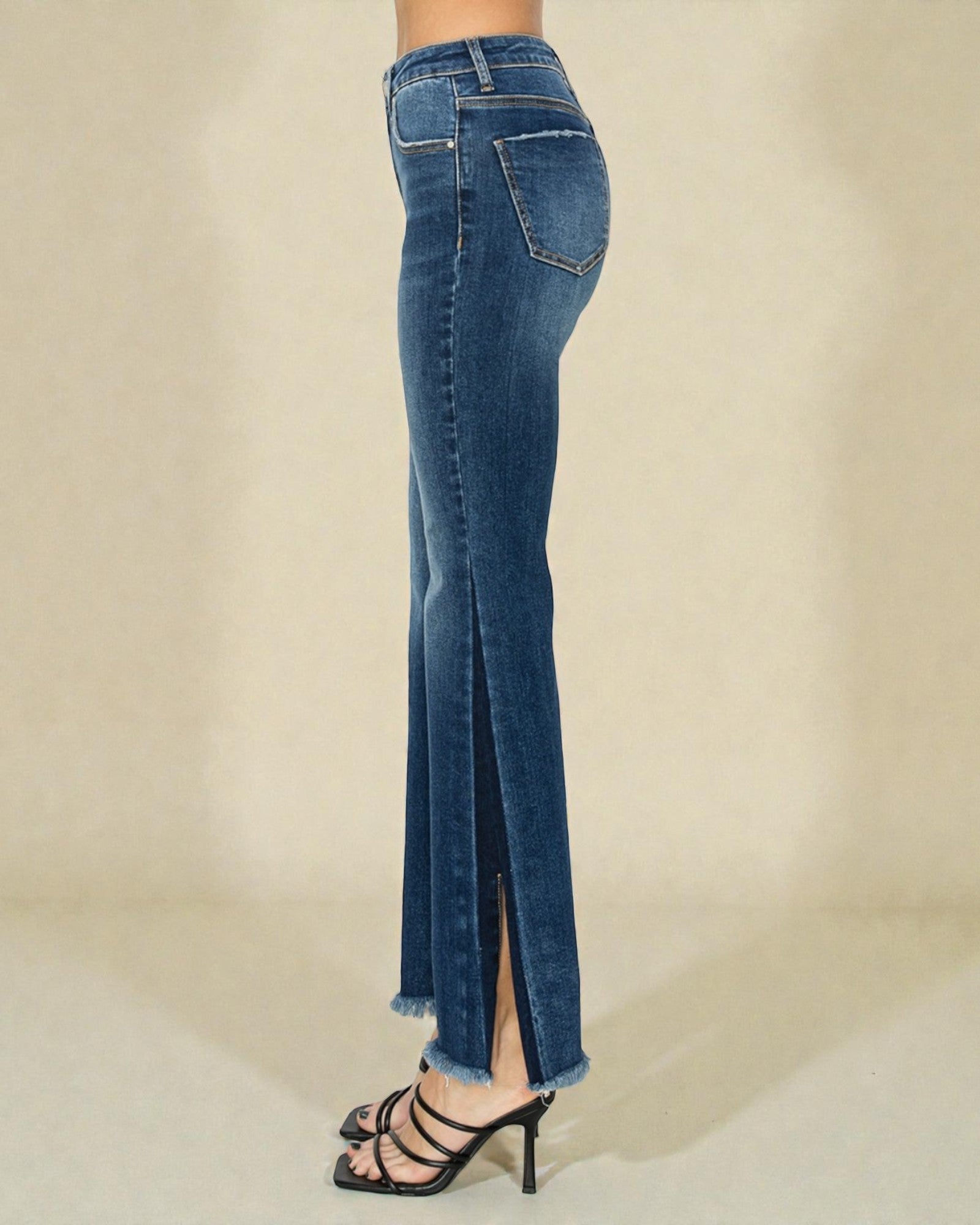 Blue jeans with a slit on a beige background