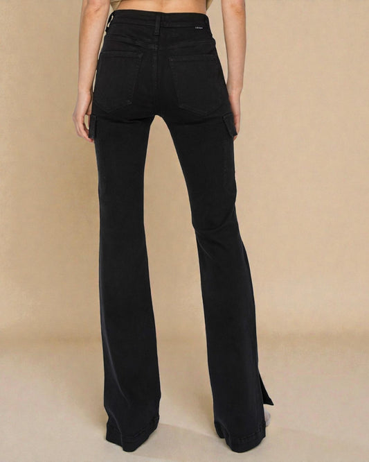 Black flared pants worn by a person on a beige background