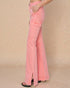Pink flared jeans worn by a person on a beige background