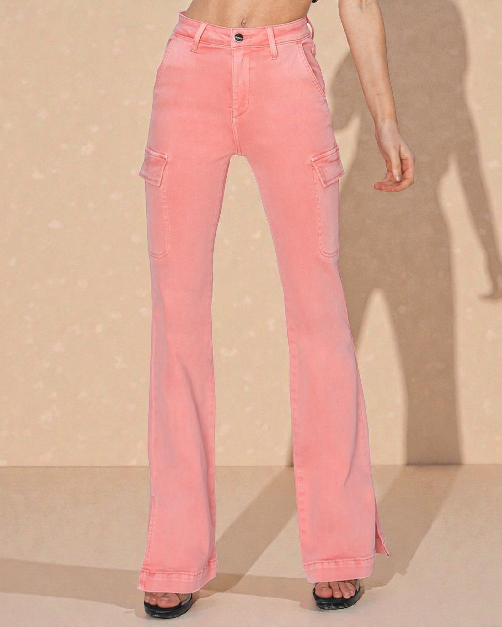 Pink flared jeans worn by a person on a beige background