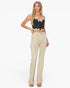 A woman modeling a black and white striped crop top with white lace trim and beige flared cargo jeans against a plain white background.