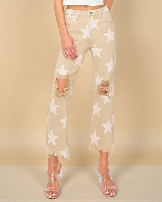 Beige pants with star pattern worn by a person on a beige background