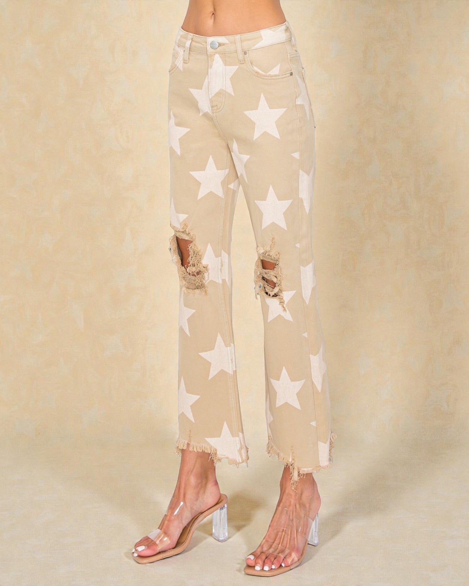 Beige pants with star pattern worn by a person on a beige background