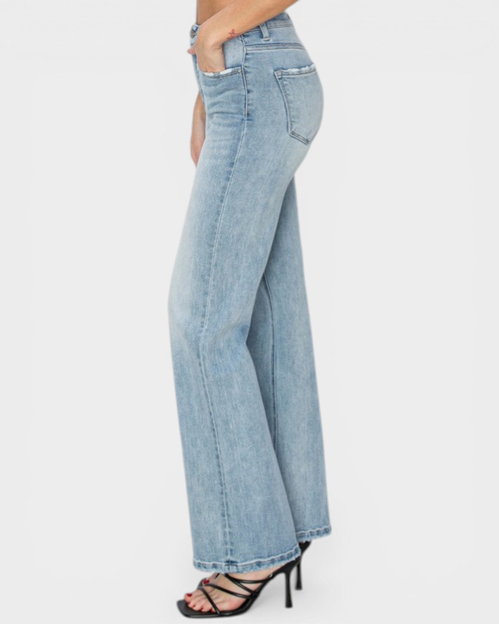 Light blue flared jeans worn by a person on a white background
