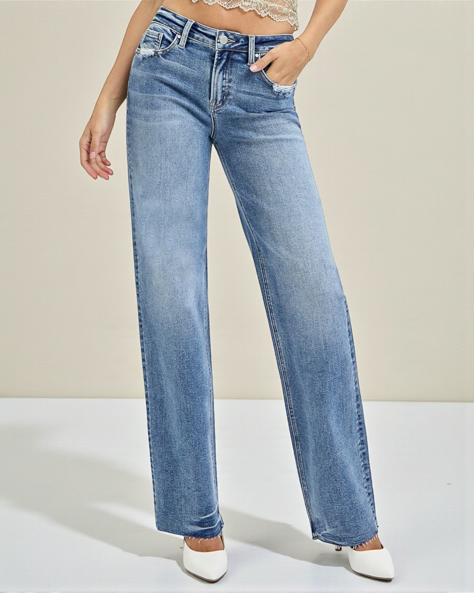 Person wearing light blue jeans on a plain background