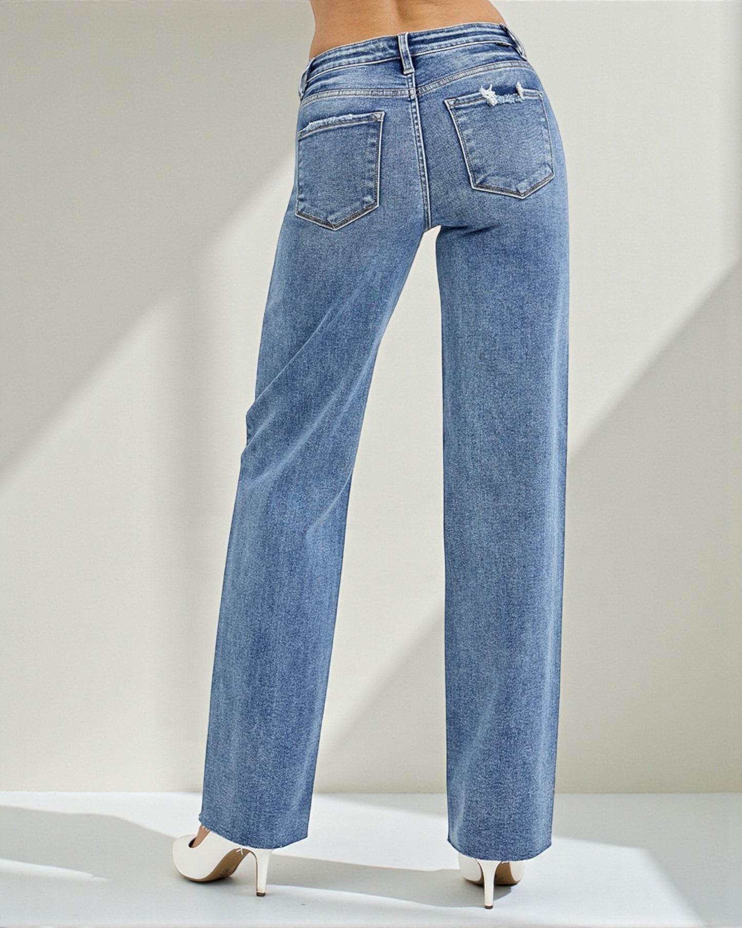 Blue jeans worn by a person on a light gray background