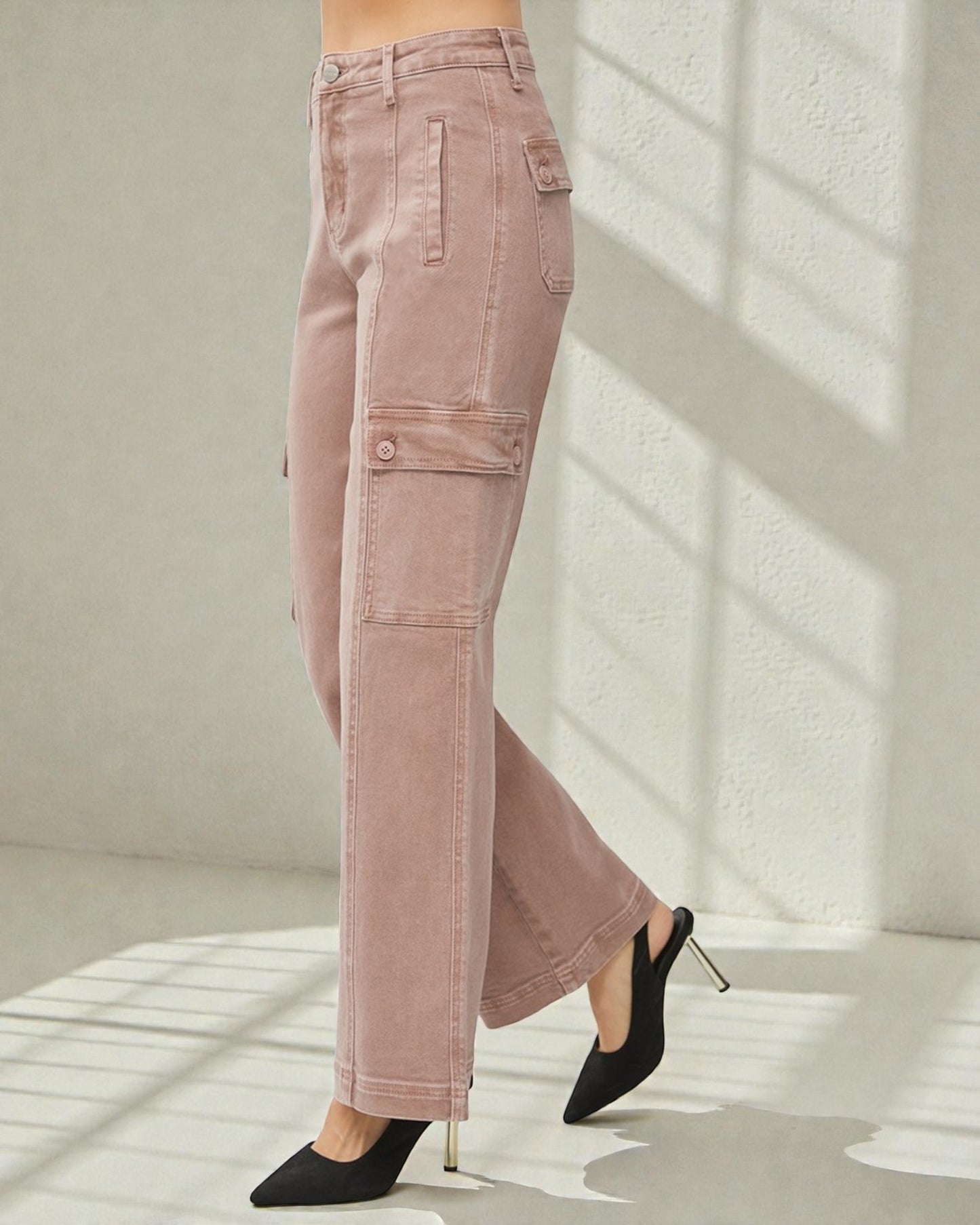 Pink pants worn by a person with black high-heeled shoes on a light background
