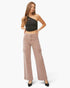 A woman modeling a black one-shoulder crop top and dusty rose wide-leg cargo pants against a plain white studio background.