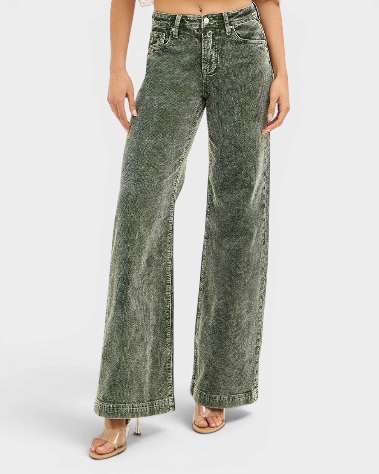 Green acid-wash jeans worn by a person on a white background