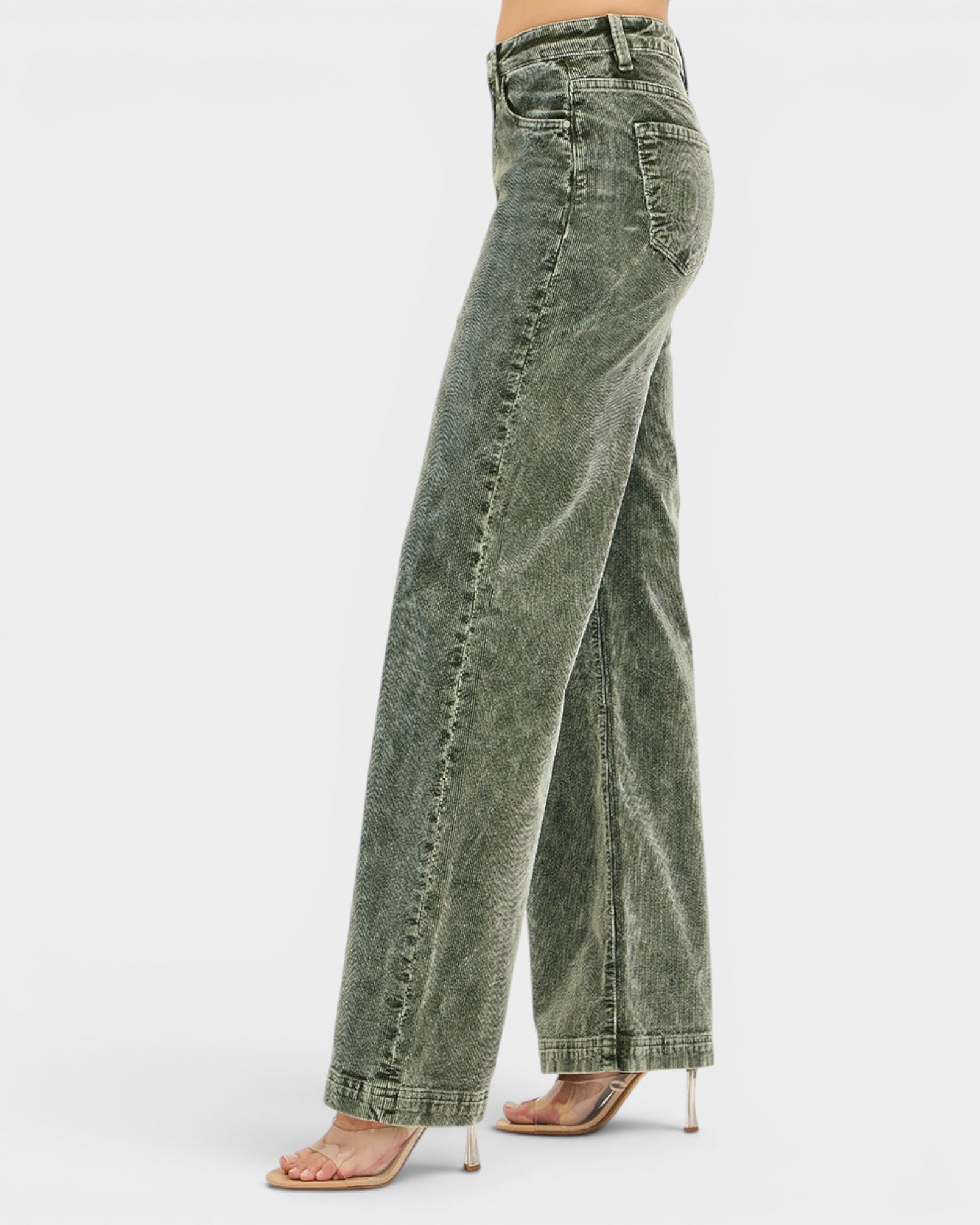 Green jeans worn by a person on a white background