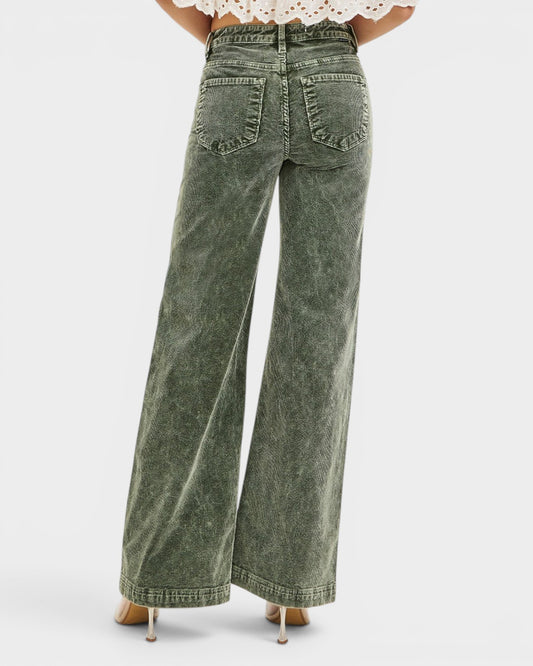Green wide-leg jeans worn by a person on a white background