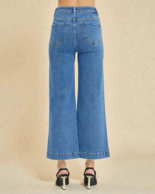 Blue jeans worn by a person on a beige background