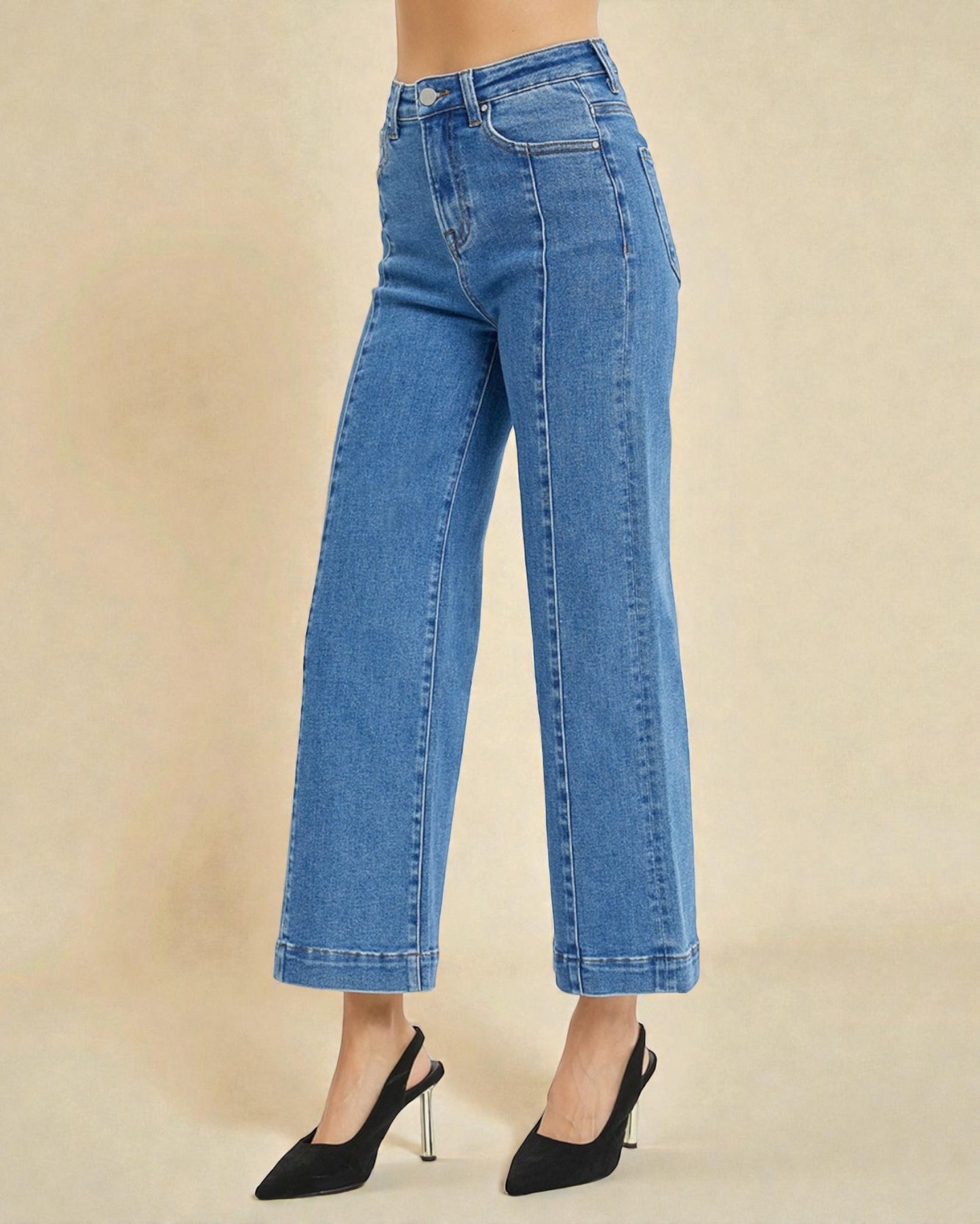 Blue jeans worn by a person on a beige background