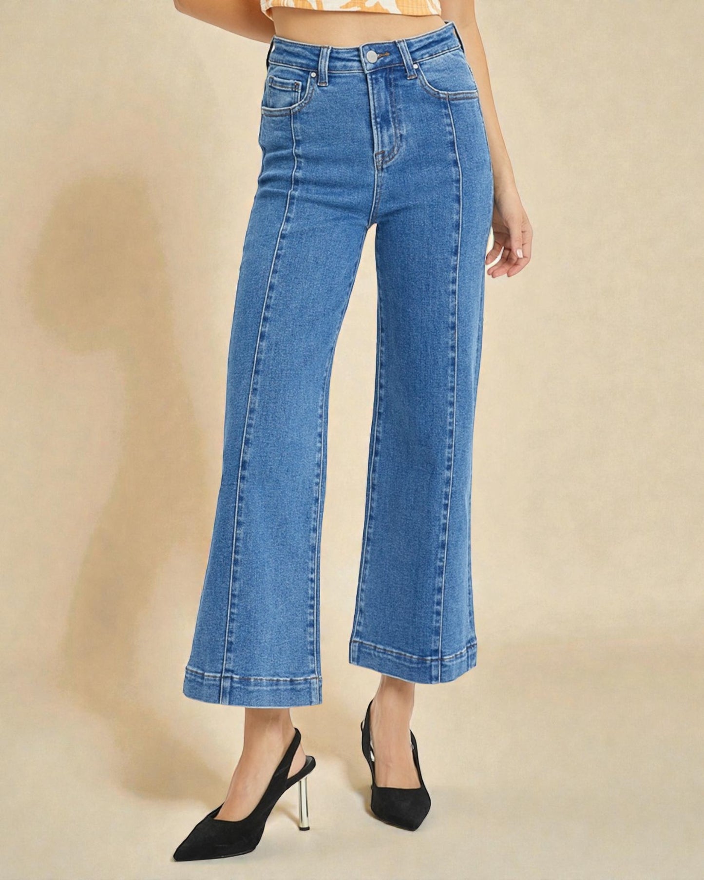 Person wearing blue jeans on a beige background