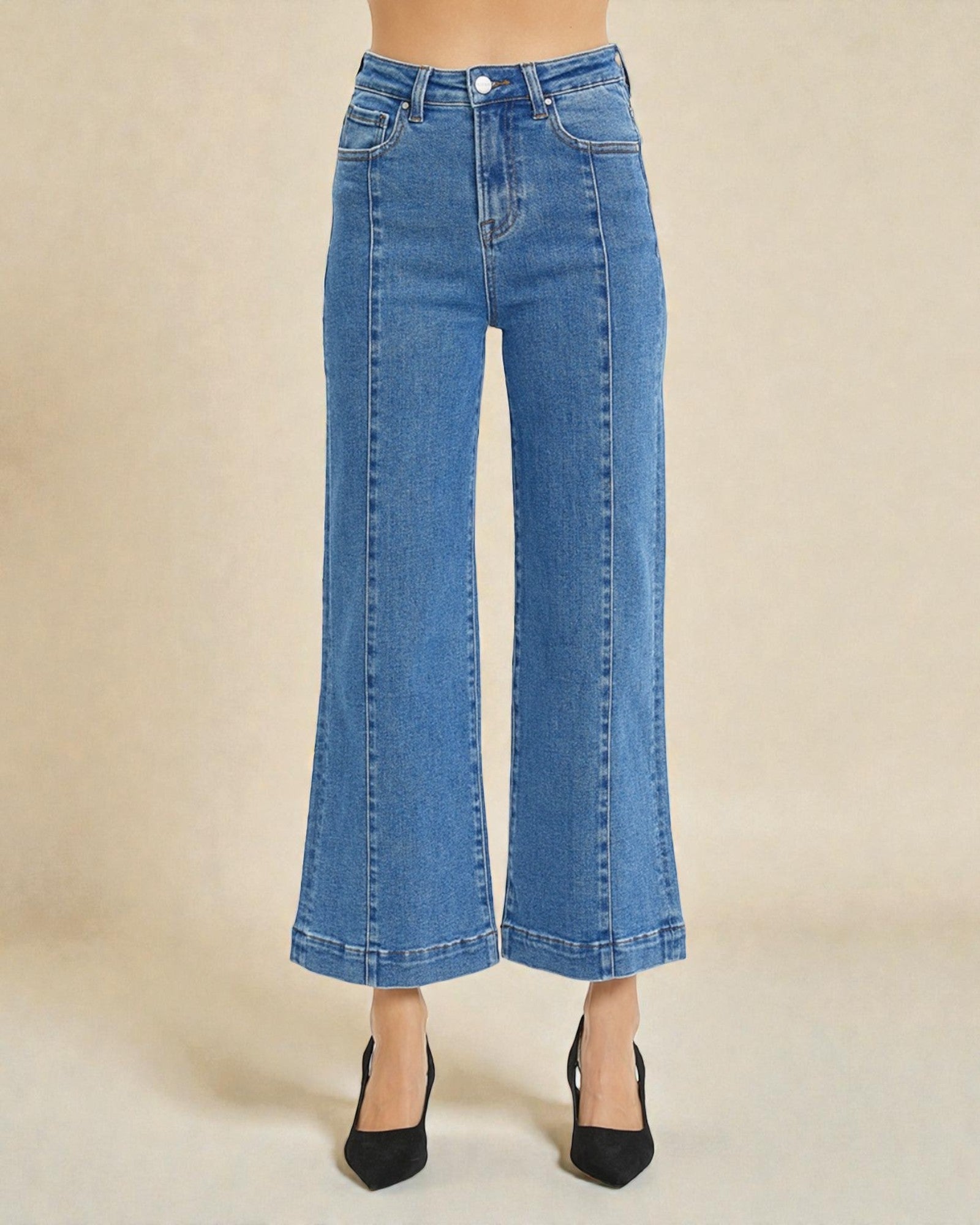 Blue jeans worn by a person on a beige background