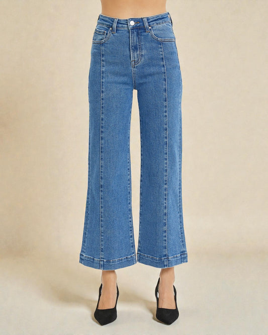 Blue jeans worn by a person on a beige background