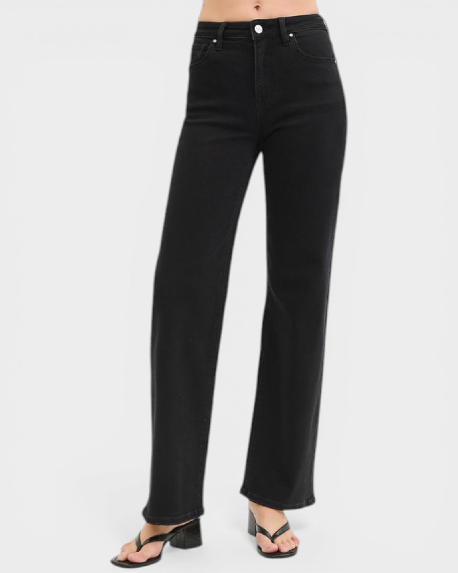 Black jeans worn by a person on a white background