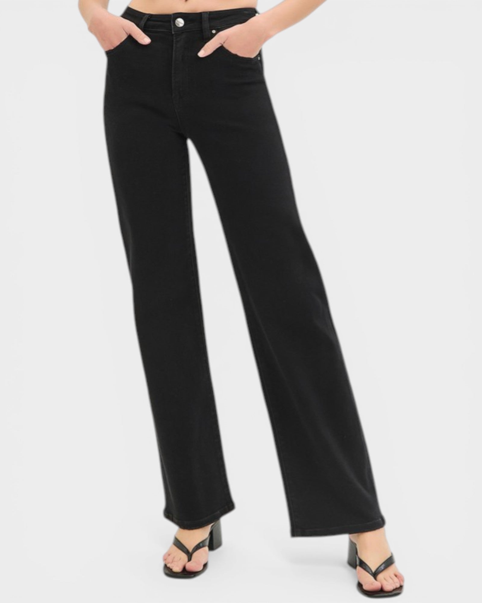 Black jeans worn by a person on a white background