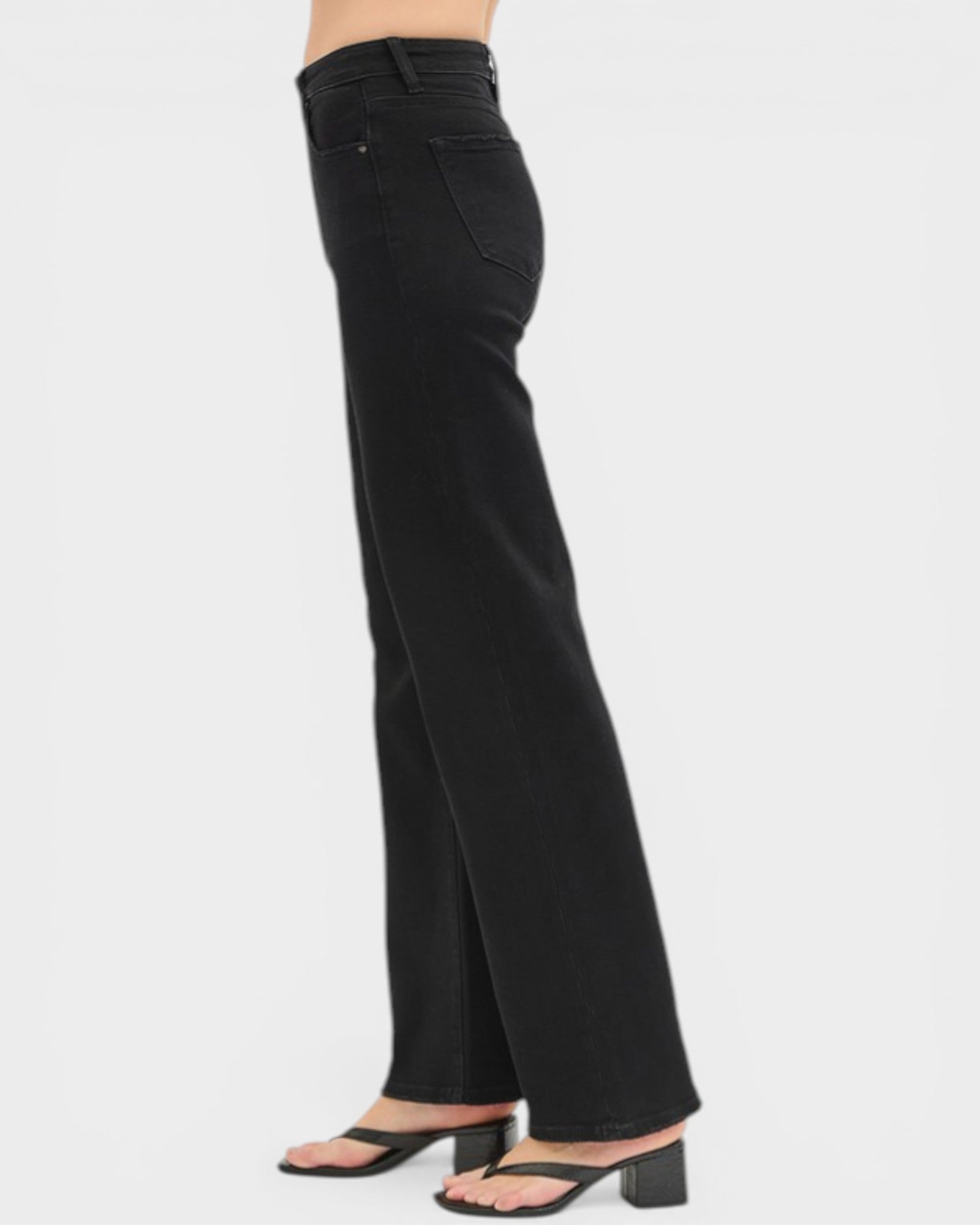 Black wide-leg jeans worn by a person on a white background