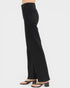 Black wide-leg jeans worn by a person on a white background