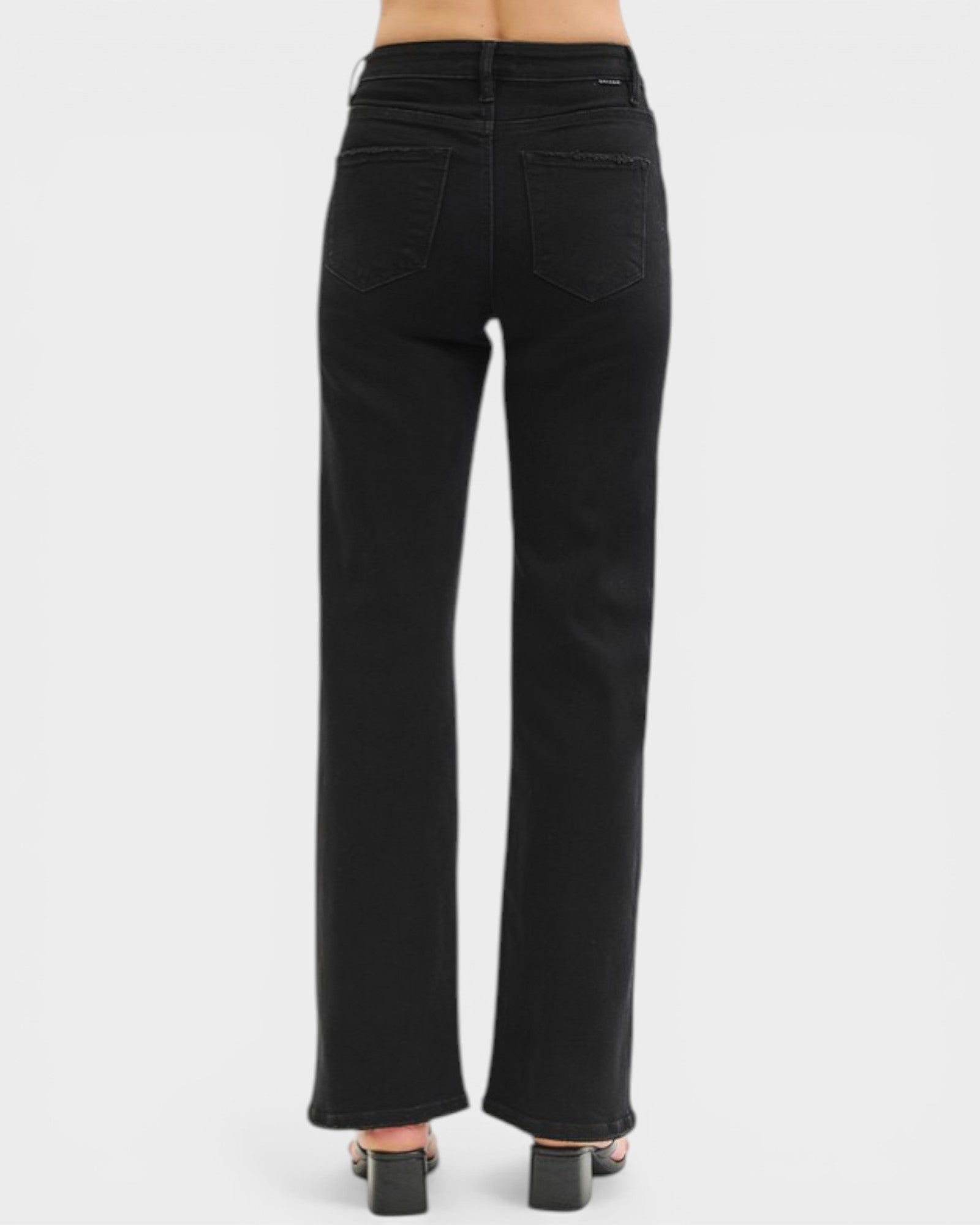 Black jeans worn by a person on a white background