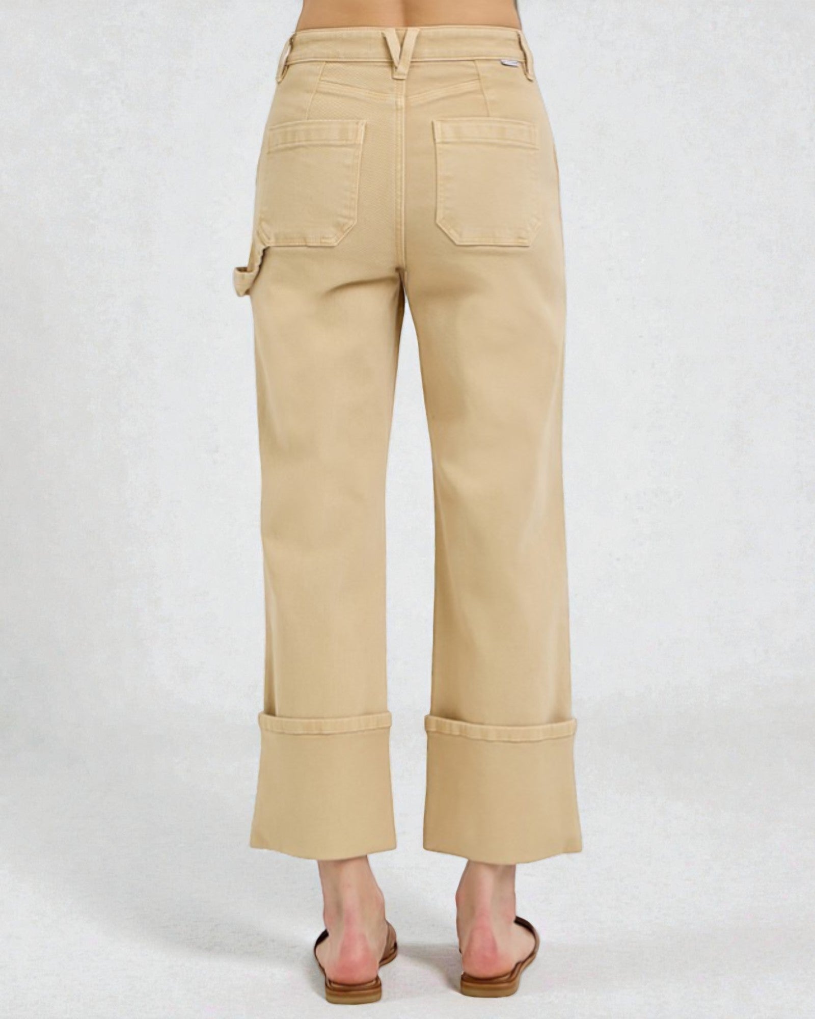 Beige pants worn by a person on a white background