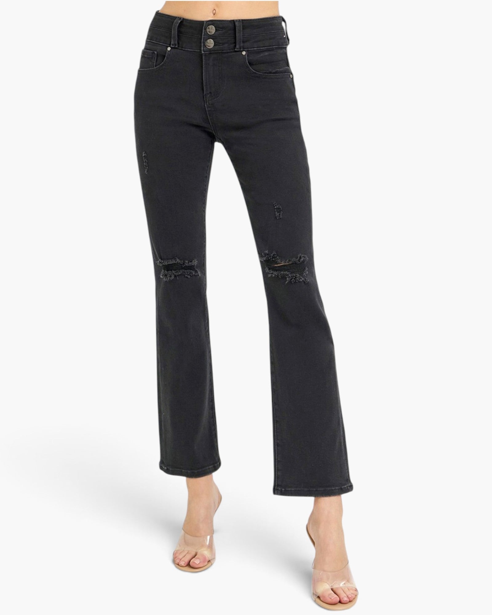 Black high-waisted cropped flare jeans with distressed details on the knees, shown on a model wearing clear high-heeled sandals against a white studio background.