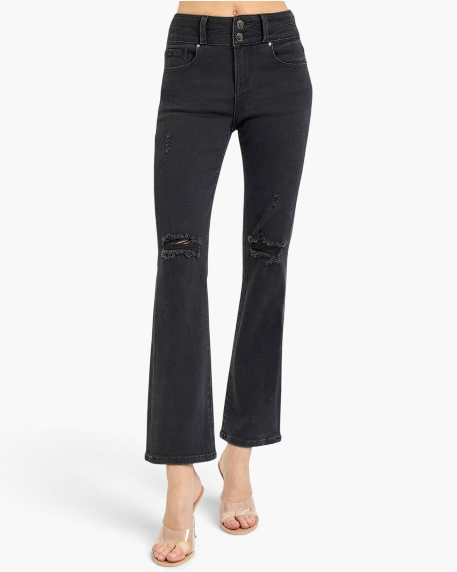 Black high-waisted cropped flare jeans with distressed details on the knees, shown on a model wearing clear high-heeled sandals against a white studio background.