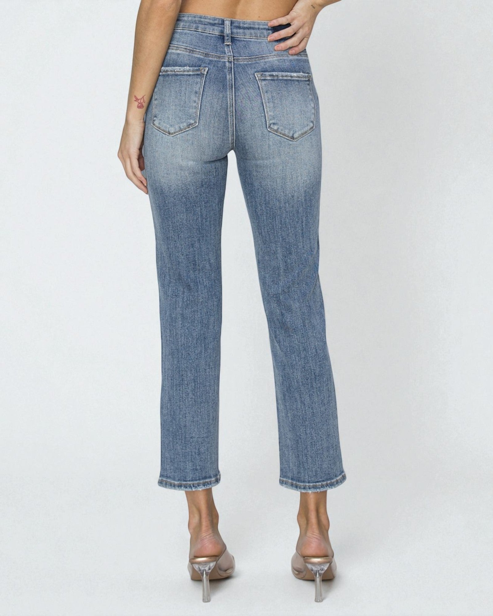 Blue jeans worn by a person on a white background