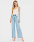 Woman wearing light blue jeans and a white top on a white background