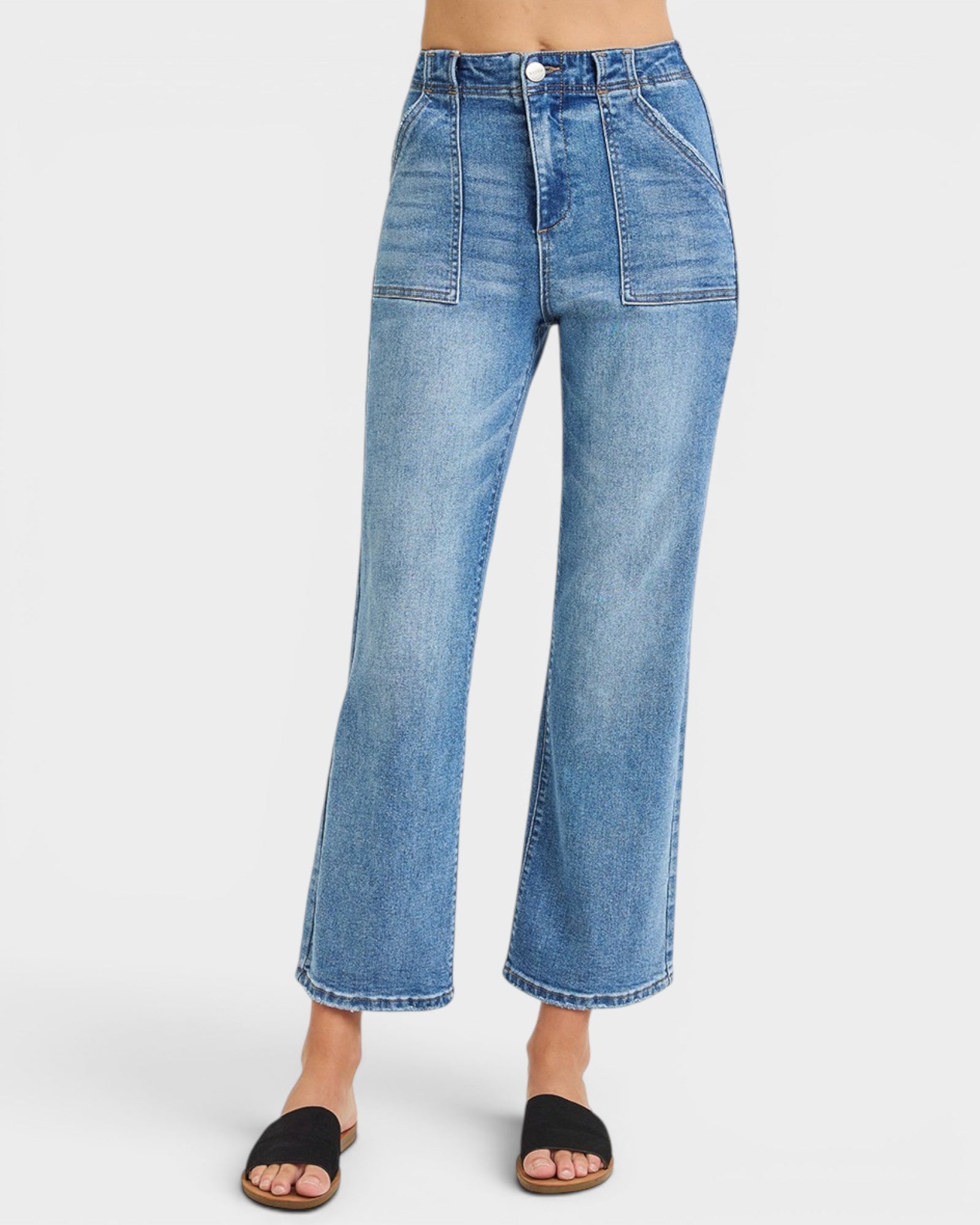 Blue jeans worn by a person on a white background