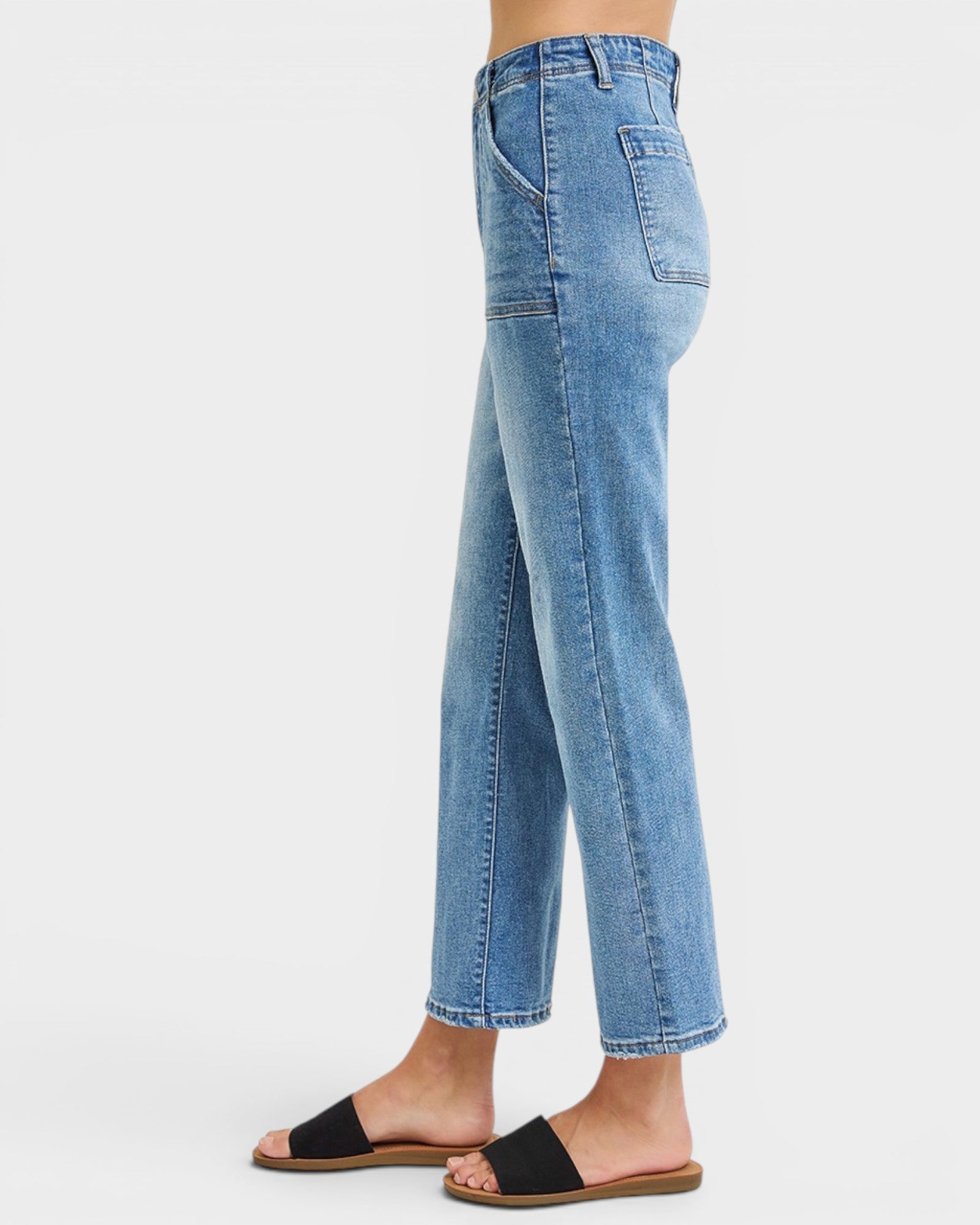 Blue jeans worn by a person on a white background