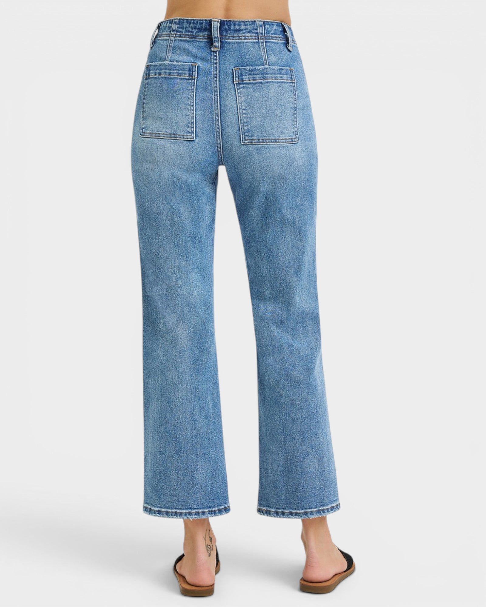 Blue jeans worn by a person on a white background