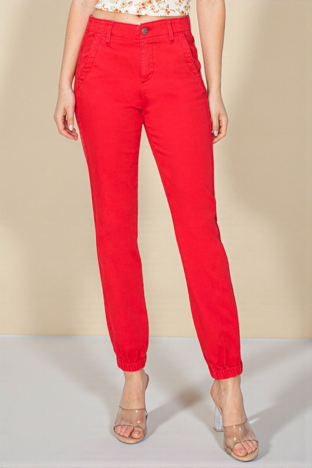 Red pants worn by a person on a beige background