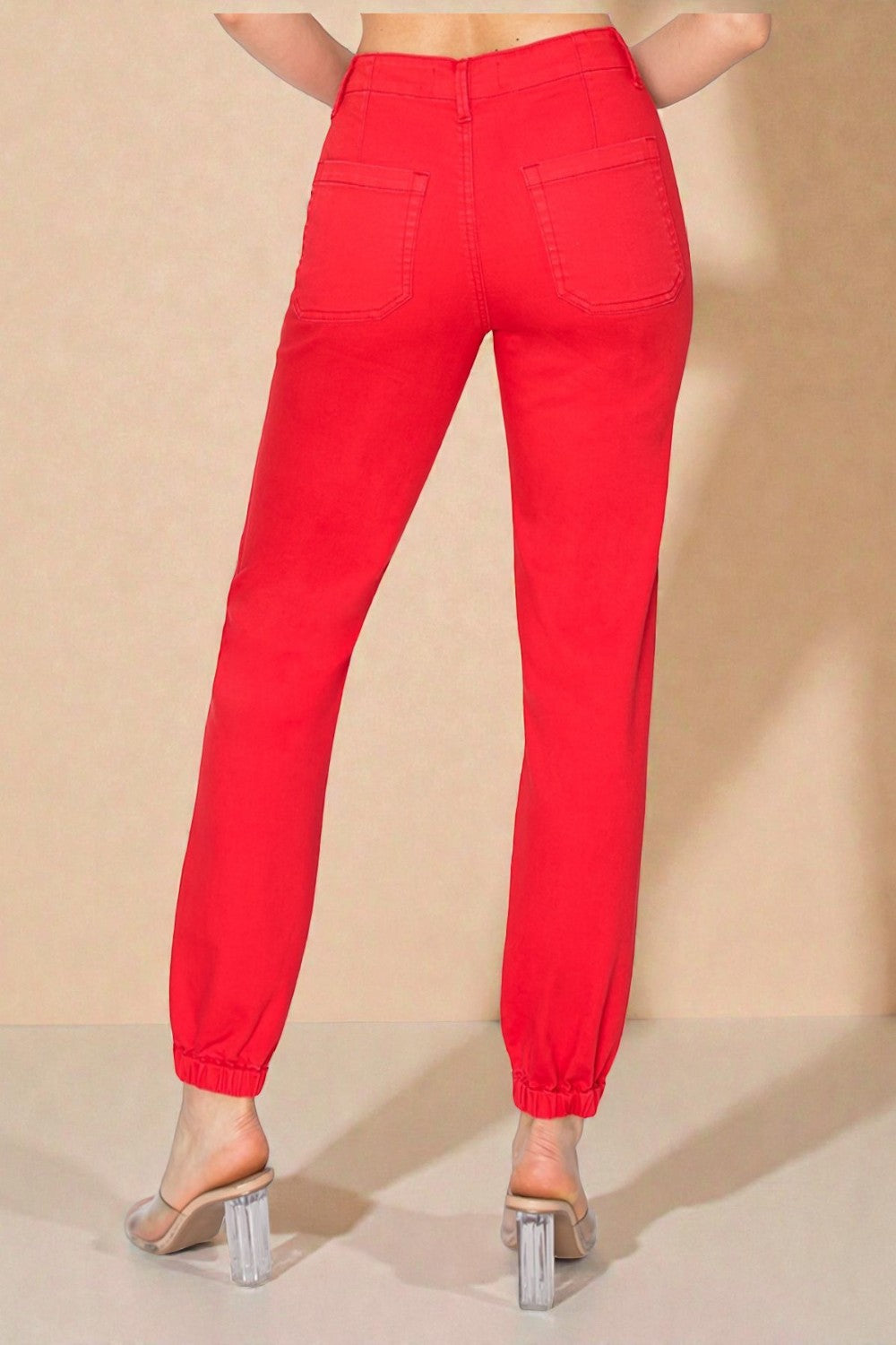 Red pants worn by a person on a beige background