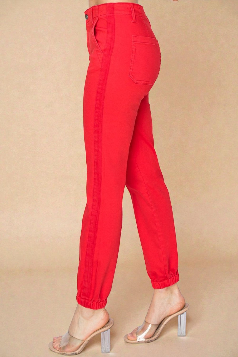 Red pants worn by a person on a beige background