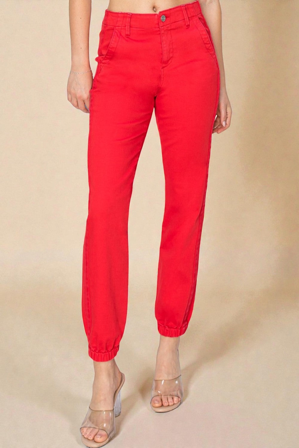 Red pants worn by a person on a beige background