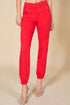 Red pants worn by a person on a beige background