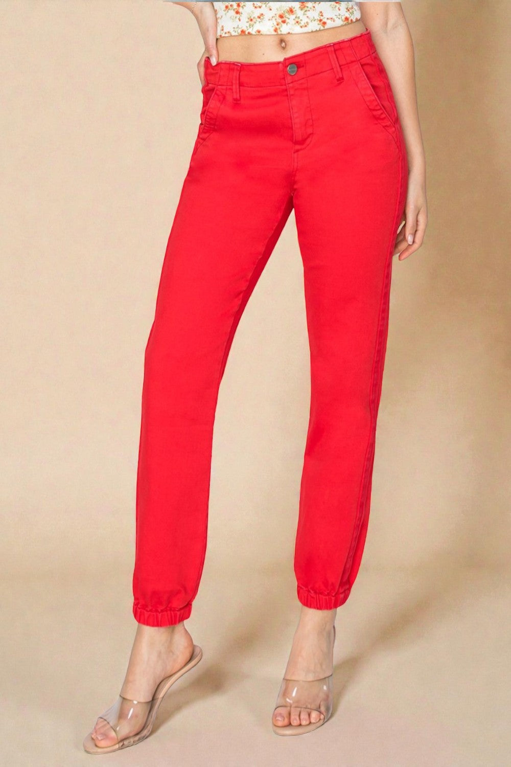 Red pants worn by a person on a beige background