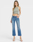 Woman wearing a green tank top and blue jeans on a white background