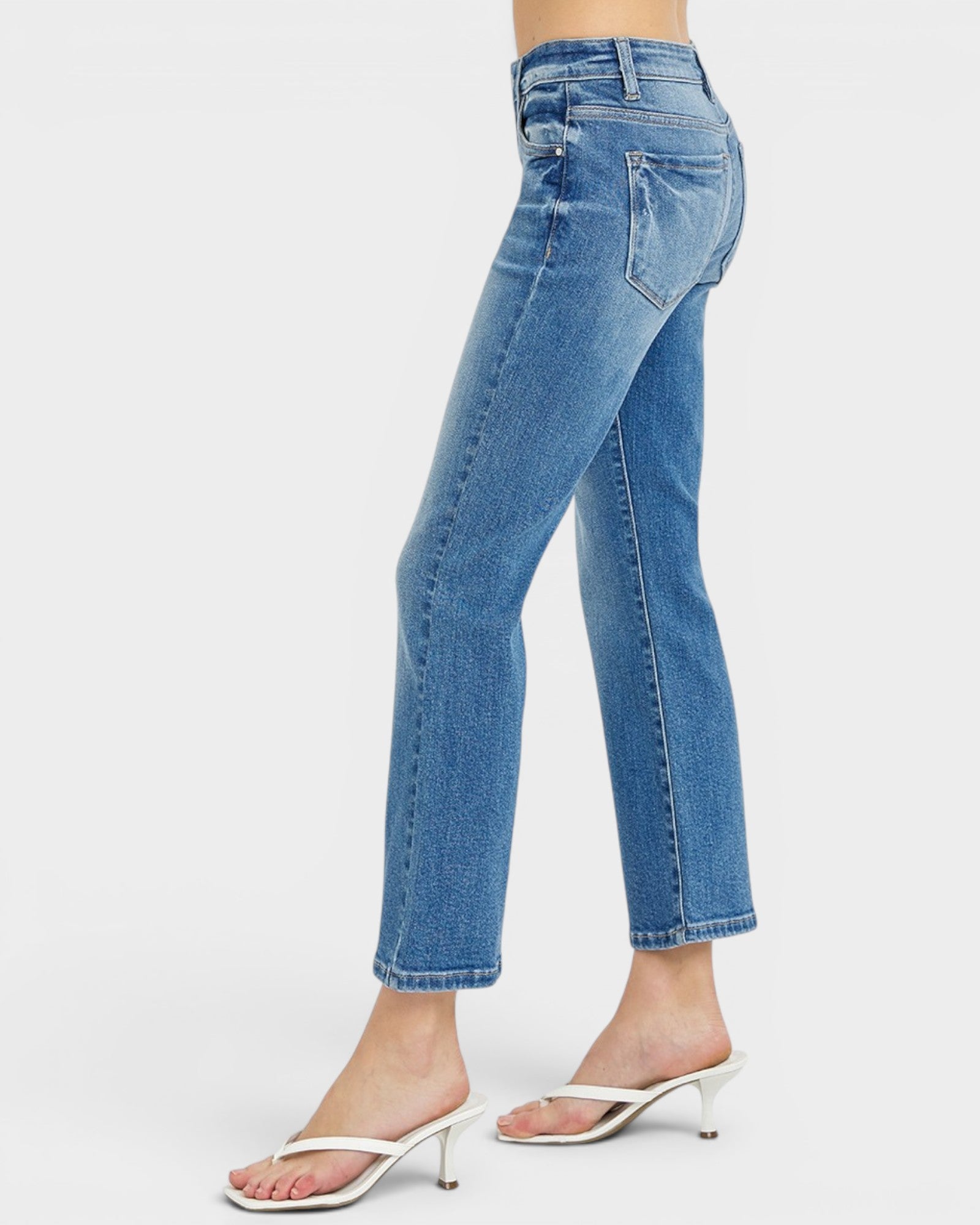 Blue jeans worn by a person on a white background