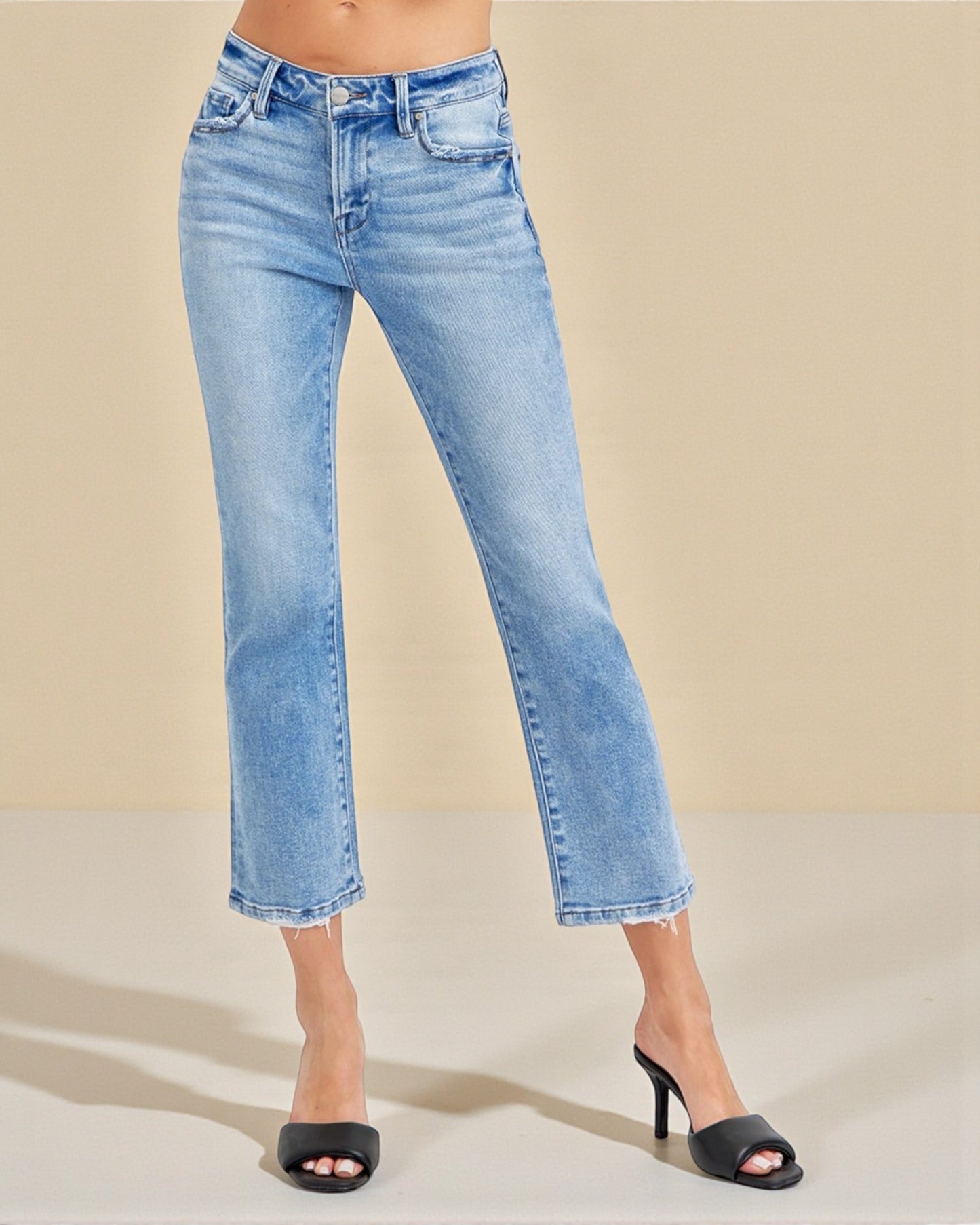 Light blue jeans worn by a person on a beige background