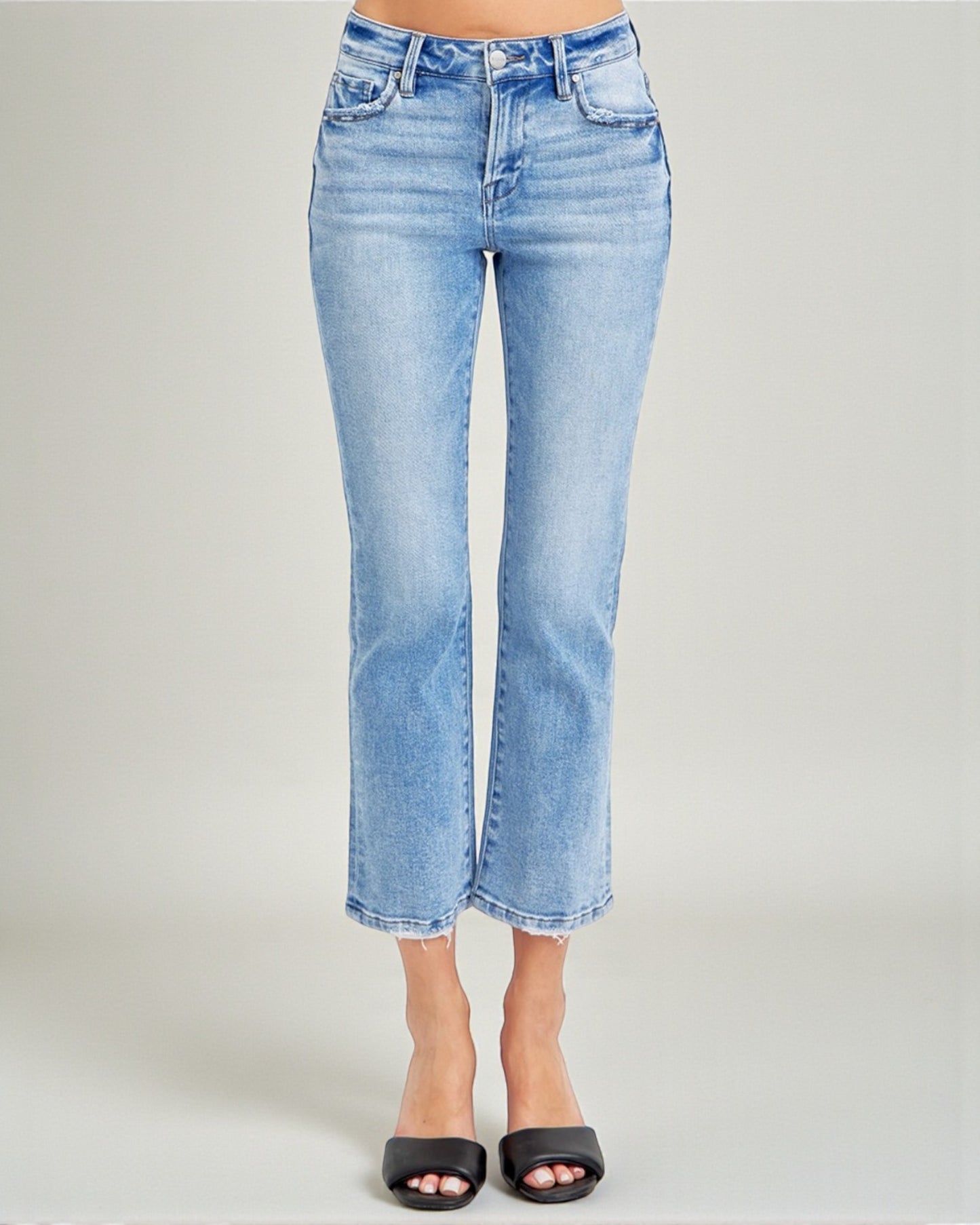 Light blue jeans worn by a person on a gray background