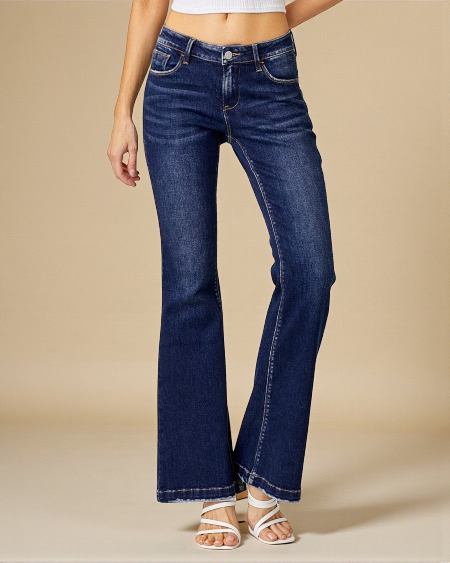 Blue jeans worn by a person on a beige background